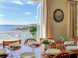 A dining room with a table set for dinner at Looe Island View in Downderry