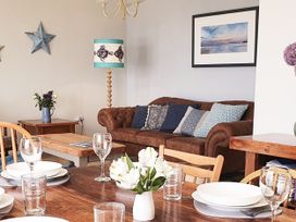 A dining room with a table and chairs at Looe Island View in Downderry