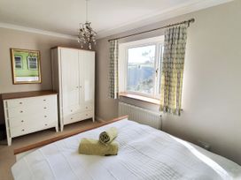 A bedroom with a bed and furniture at Looe Island View in Downderry