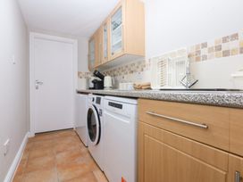 A laundry room with a washing machine and a dishwasher at Oak Cottage in Dinas Dinlle near Caernarfon