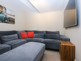 A living room with a sofa and wall art at Oak Cottage in Dinas Dinlle near Caernarfon