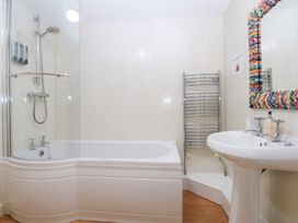 A bathroom with a bathtub and sink at Oak Cottage Dinas Dinlle near Caernarfon