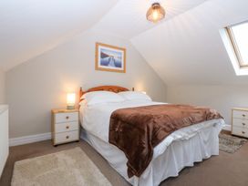 A bedroom with a bed and bedside table at Oak Cottage in Dinas Dinlle near Caernarfon
