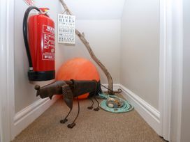 A hallway with a fire extinguisher and a metal dog sculpture at Oak Cottage Dinas Dinlle near Caernarfon
