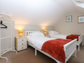 A bedroom with two beds and a nightstand at Oak Cottage Dinas Dinlle near Caernarfon