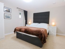 A bedroom with a bed and bedside tables at Oak Cottage in Dinas Dinlle near Caernarfon