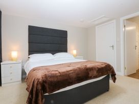 A bedroom with a bed and nightstand at Oak Cottage Dinas Dinlle near Caernarfon