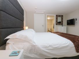 A bedroom with a bed and a television at Oak Cottage Dinas Dinlle near Caernarfon