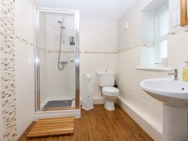 A bathroom with a shower, toilet and sink at Oak Cottage Dinas Dinlle near Caernarfon