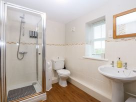 A bathroom with a shower, toilet and sink at Oak Cottage Dinas Dinlle near Caernarfon
