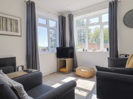 A living room with a television and sofa at Lyme Zest in Lyme Regis
