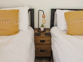 A bedroom with two beds and a nightstand at Lyme Zest in Lyme Regis