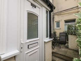 A door leading to a patio area with a table and chairs at Saddlers Cottage in Weymouth