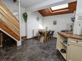 A dining room with a table and chairs at Saddlers Cottage in Weymouth