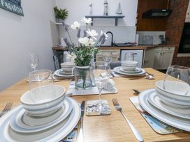 A dining table set with plates and glasses at Saddlers Cottage in Weymouth