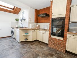 A kitchen with a washing machine and oven at Saddlers Cottage in Weymouth