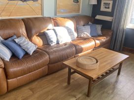 A living room with a sofa and coffee table at Seaspray in St Bees