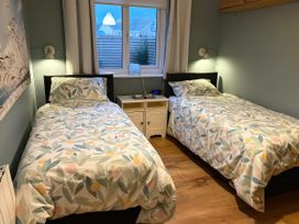 A bedroom with two beds and a window at Seaspray in St Bees