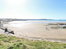 A beach with houses and a clear sea at The Waves Little Haven near Broad Haven