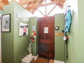 A hallway with a door, picture, and fire extinguisher at The Old Byre in Woodfalls