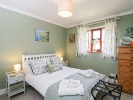 A bedroom with a bed and window at The Old Byre in Woodfalls