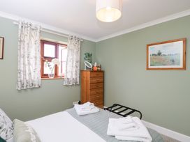 A bedroom with a bed and dresser at The Old Byre in Woodfalls