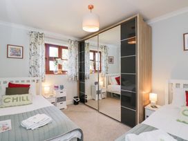 A bedroom with two beds and a wardrobe at The Old Byre in Woodfalls