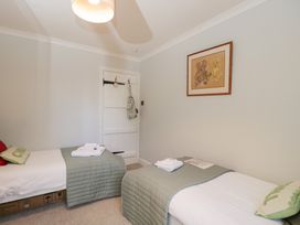 A bedroom with two beds and a painting at The Old Byre in Woodfalls