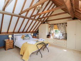 A bedroom with a bed and wardrobe at The Old Byre in Woodfalls