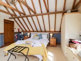 A bedroom with a bed and bedside table at The Old Byre in Woodfalls