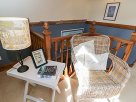 A landing area with a chair and a lamp at The Old Byre in Woodfalls
