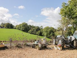 An outdoor area with a tractor and flower pots at The Old Byre in Woodfalls