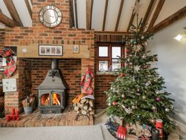 A living room with a fireplace and a Christmas tree at The Old Byre in Woodfalls