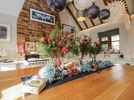 A kitchen with a dining table decorated with vases and festive elements at The Old Byre in Woodfalls