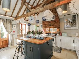 A kitchen with a central island and stove at The Old Byre in Woodfalls