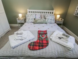 A bedroom with a bed made and towels on display at The Old Byre in Woodfalls