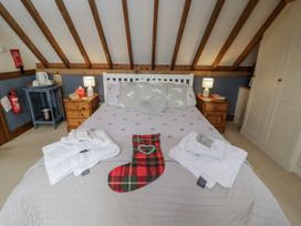 A bedroom with a bed, towels, and a stocking at The Old Byre in Woodfalls