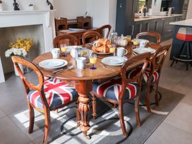 A dining room table with plates and drinks at Cavan Cottage Yoxford