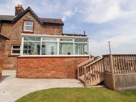 A conservatory with stone wall and steps at Rose Bank Cottage in Dalston