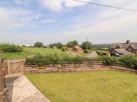 A garden with gate and grass at Rose Bank Cottage in Dalston