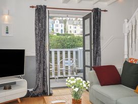 A living room with a TV and a sliding door at 3 River View Looe