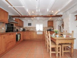 A kitchen with wooden cabinets and a table at 3 River View in Looe