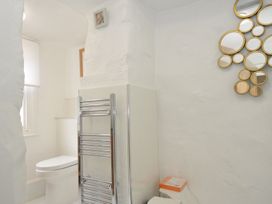 A bathroom with a toilet and a mirror at 3 River View in Looe