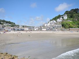 A beach scene with people and houses at 3 River View in Looe