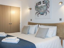 A bedroom with a bed and wall art at 5 Harbour Yard Salcombe