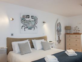A bedroom with a bed and artwork at 5 Harbour Yard in Salcombe