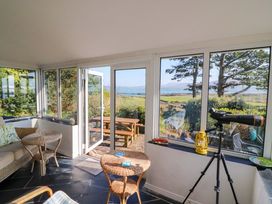 A conservatory with a table, chairs and telescope at Whispering Pines in Durrus, County Cork