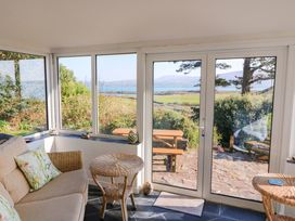 A conservatory with a sofa and coffee table at Whispering Pines in Durrus, County Cork