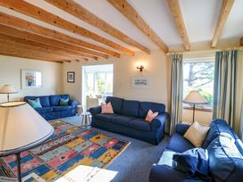 A living room with blue sofas and a lamp at Whispering Pines in Durrus, County Cork
