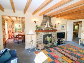 A living room with a fireplace and sofa at Whispering Pines in Durrus, County Cork